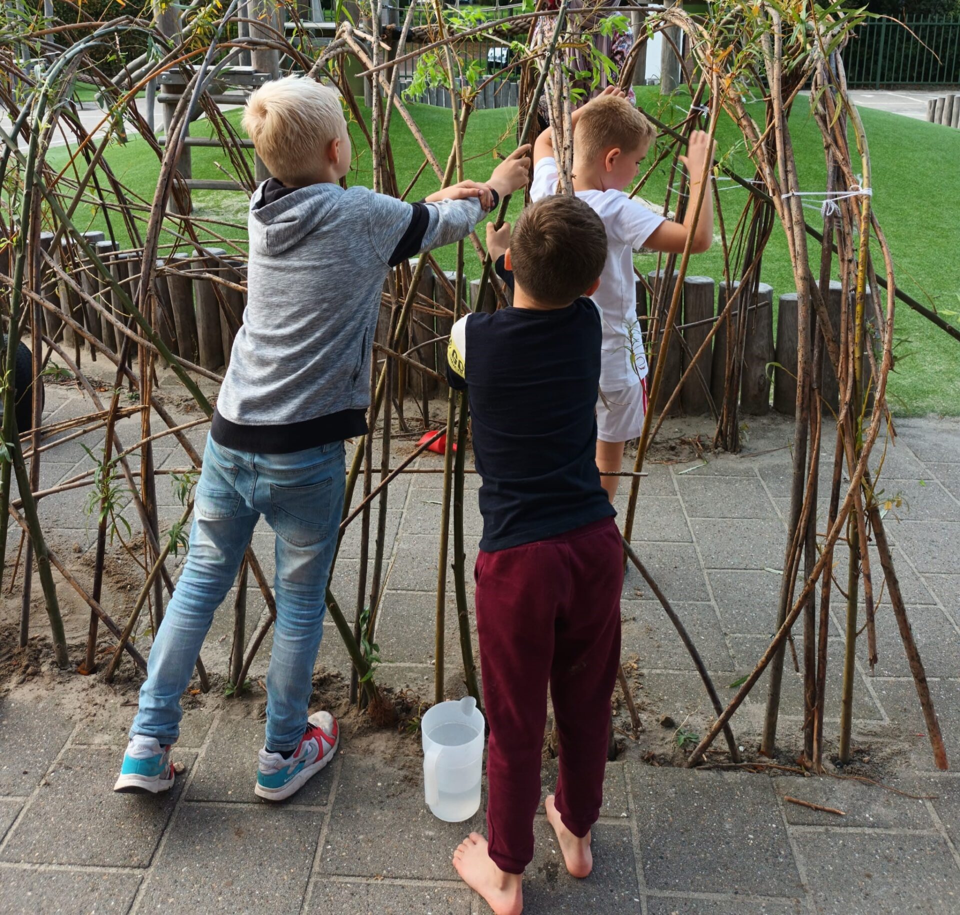 Kinderen van de bso aan het ontdekken op het schoolplein bij SKH kinderopvanghuizen 