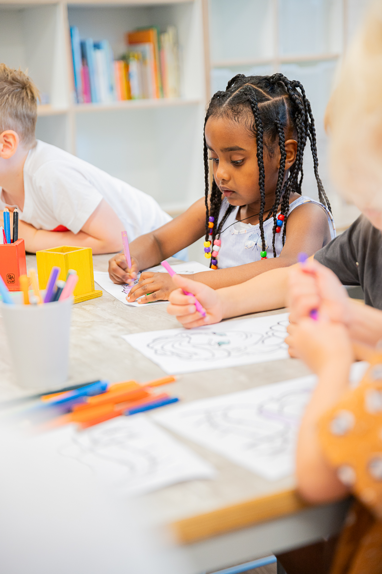 Meisje op de bso van kinderopvang huizen aan die leuk aan het tekenen is. 