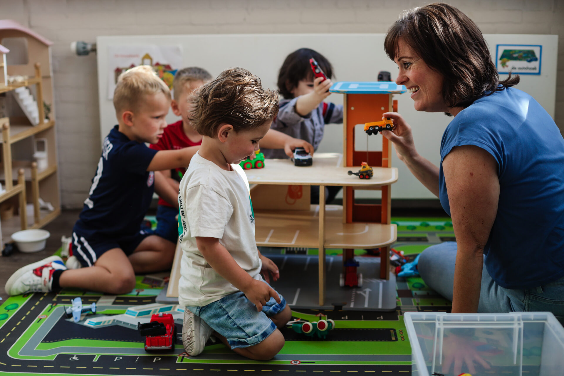 Een liefdevolle medewerker die aan het spelen in met de kinderen bij stichting kinderopvang huizen SKH